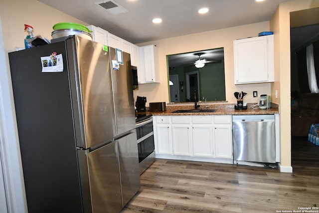 kitchen with stainless steel appliances, wood-type flooring, sink, and white cabinets