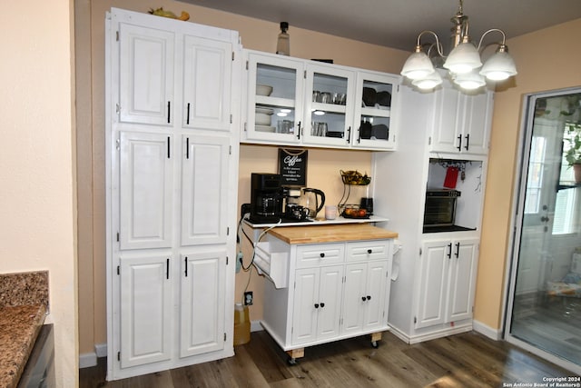 kitchen with white cabinets, dark wood-type flooring, a chandelier, and hanging light fixtures