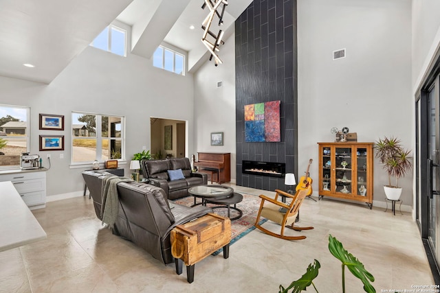 living room featuring a wealth of natural light, a tile fireplace, beam ceiling, and high vaulted ceiling