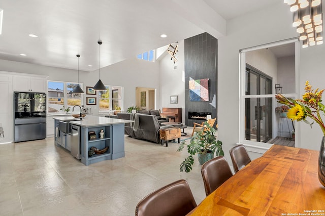 dining room with beam ceiling, sink, and a tile fireplace