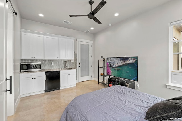 bedroom featuring a barn door, sink, connected bathroom, and ceiling fan