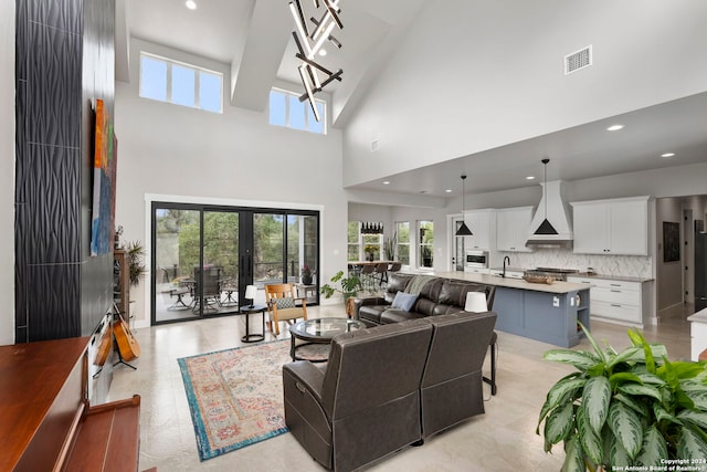 living room with a towering ceiling, sink, and plenty of natural light