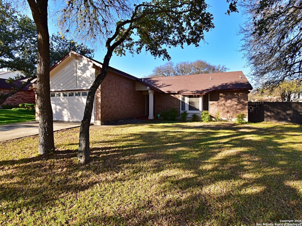 ranch-style home featuring a front yard and a garage