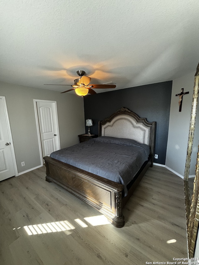 bedroom featuring ceiling fan, a textured ceiling, and hardwood / wood-style floors