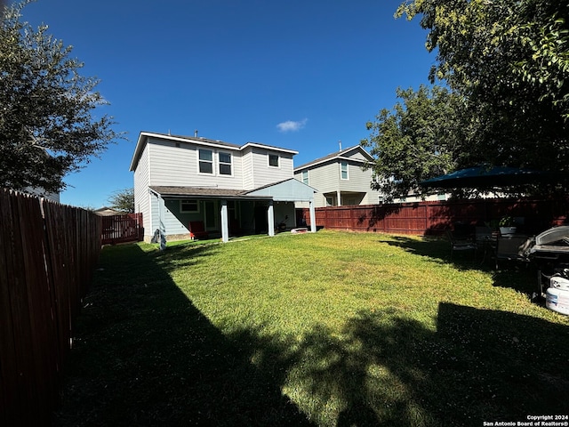 back of property featuring a lawn