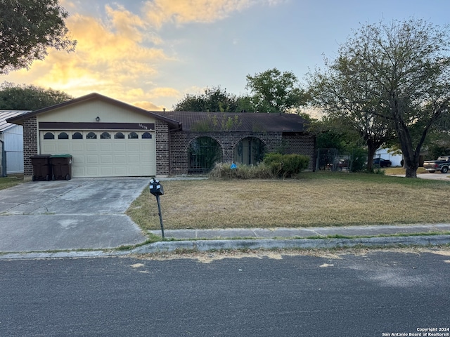 ranch-style home with a yard and a garage