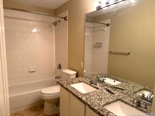 full bathroom featuring toilet, vanity, and tiled shower / bath