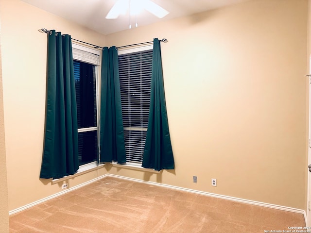 carpeted spare room with ceiling fan