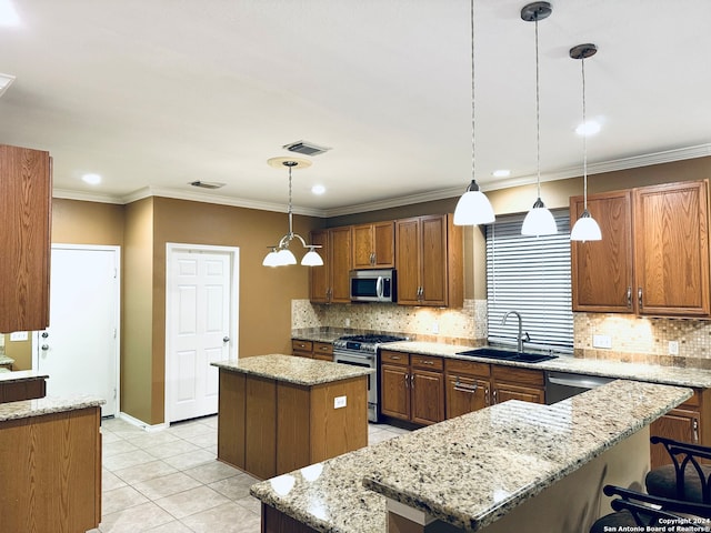 kitchen featuring light stone counters, a center island, hanging light fixtures, sink, and appliances with stainless steel finishes