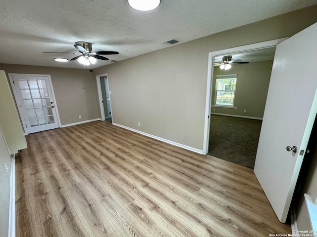 empty room featuring light hardwood / wood-style floors, a textured ceiling, and ceiling fan