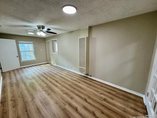 unfurnished bedroom with light hardwood / wood-style flooring, a textured ceiling, and ceiling fan