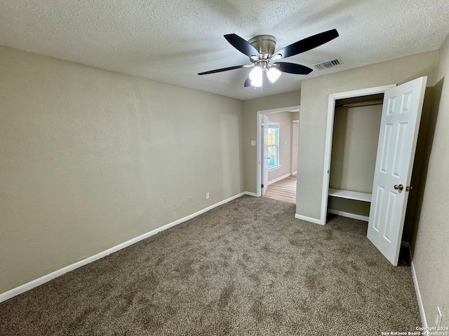 unfurnished bedroom featuring a closet, a textured ceiling, carpet flooring, and ceiling fan