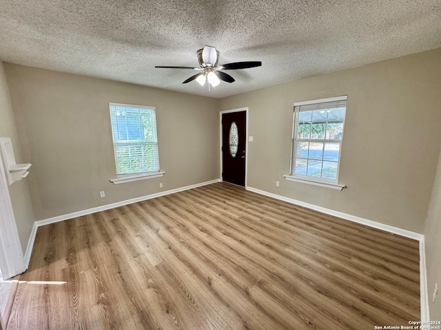 entrance foyer with a textured ceiling, light wood-type flooring, and ceiling fan