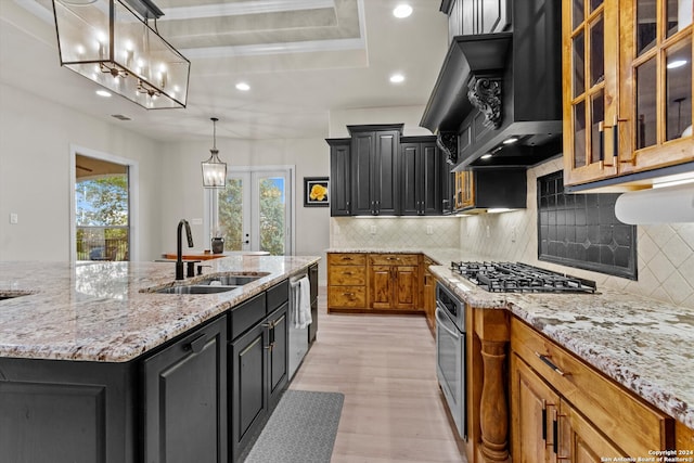 kitchen featuring light stone countertops, sink, backsplash, stainless steel appliances, and custom exhaust hood