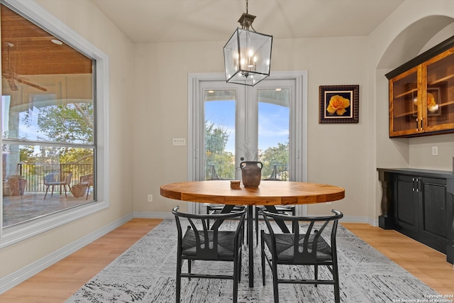 dining room with light hardwood / wood-style flooring and an inviting chandelier