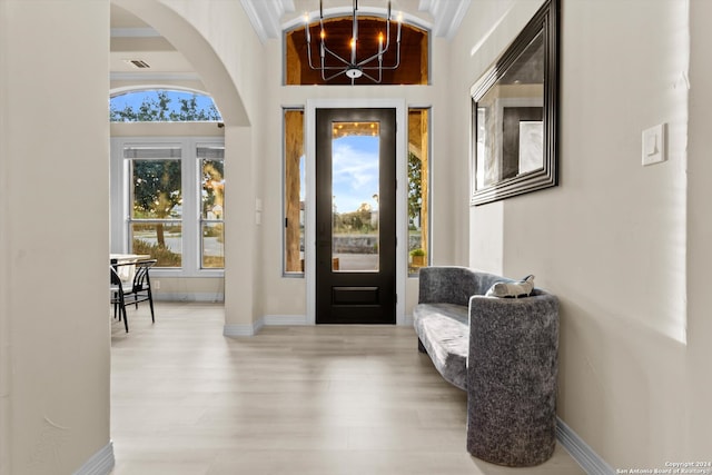 entrance foyer featuring light hardwood / wood-style flooring, ornamental molding, and a wealth of natural light