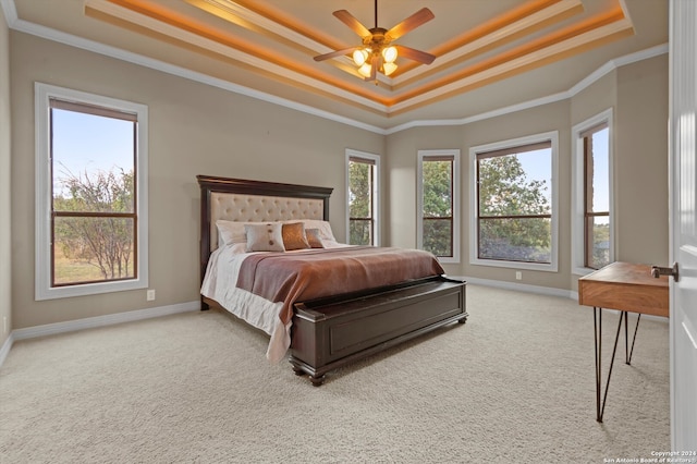 bedroom featuring ornamental molding, carpet flooring, a tray ceiling, and ceiling fan