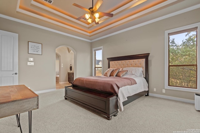 bedroom with carpet flooring, ensuite bath, a raised ceiling, ceiling fan, and crown molding