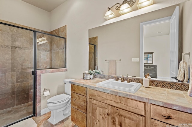 bathroom with vanity, toilet, and a shower with shower door