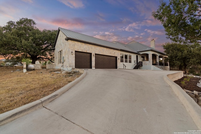 view of front facade featuring covered porch and a garage