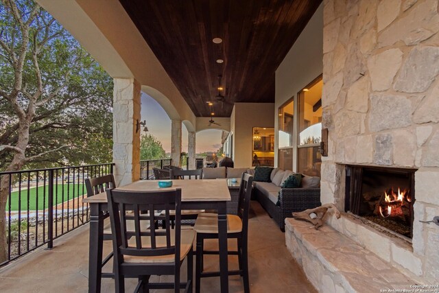 patio terrace at dusk with an outdoor living space with a fireplace