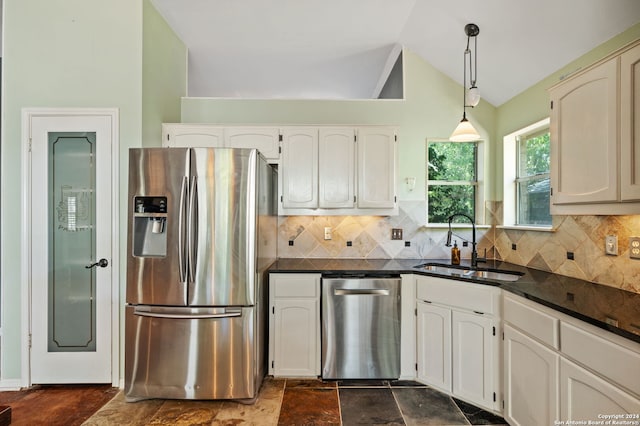 kitchen featuring appliances with stainless steel finishes, hanging light fixtures, backsplash, and vaulted ceiling