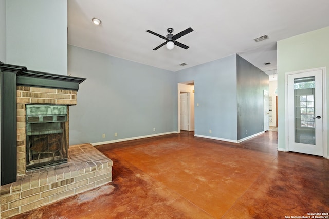 unfurnished living room with ceiling fan, a brick fireplace, and concrete flooring