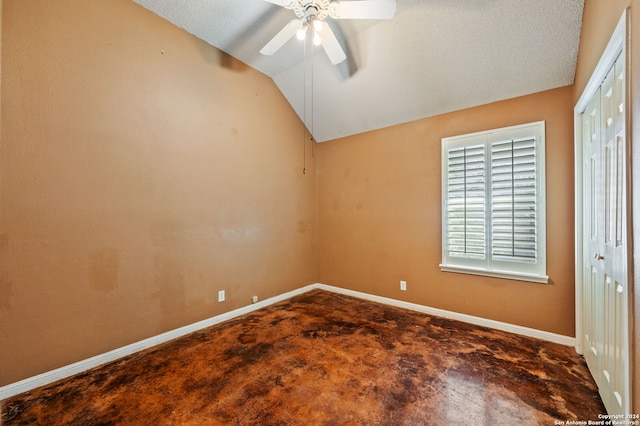 empty room featuring vaulted ceiling, a textured ceiling, and ceiling fan