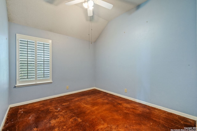 spare room with ceiling fan, a textured ceiling, lofted ceiling, and concrete floors