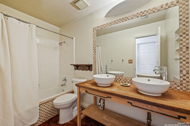 full bathroom featuring toilet, a textured ceiling, shower / bath combo, and vanity