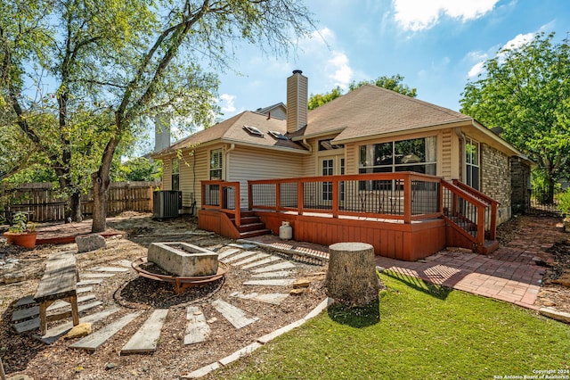 rear view of property featuring a deck and a fire pit