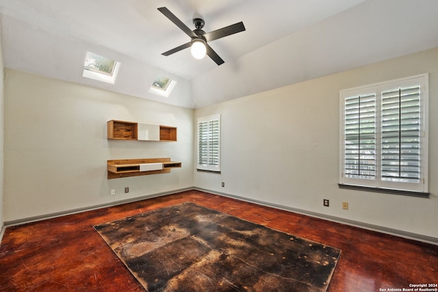 unfurnished living room featuring lofted ceiling with skylight and ceiling fan