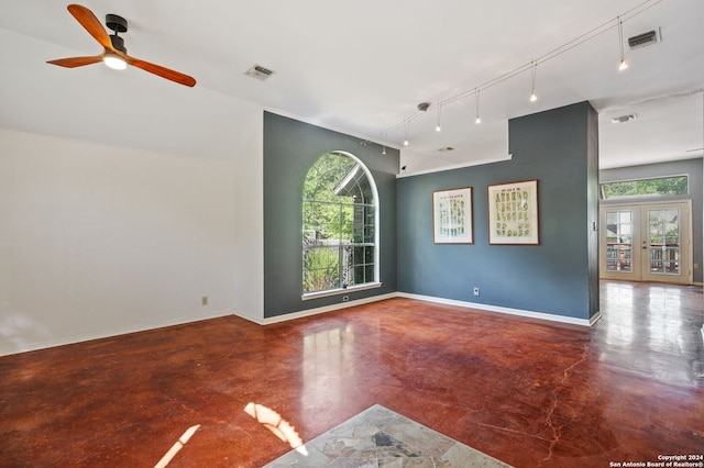 empty room with french doors, concrete floors, track lighting, and ceiling fan