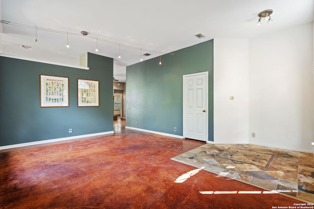 spare room with ceiling fan and track lighting