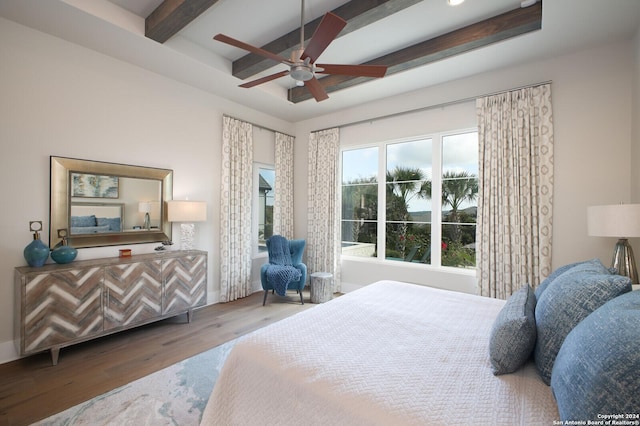 bedroom featuring ceiling fan, wood-type flooring, and beam ceiling