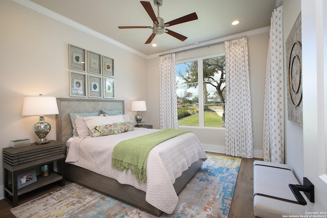 bedroom with hardwood / wood-style floors, crown molding, and ceiling fan