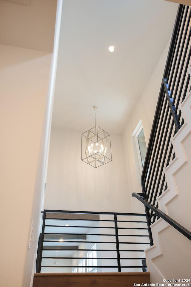 stairs with a notable chandelier