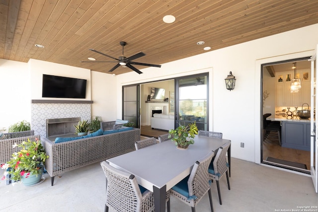 view of patio featuring ceiling fan and an outdoor living space with a fireplace