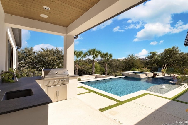 view of pool with area for grilling, sink, an in ground hot tub, grilling area, and a patio area