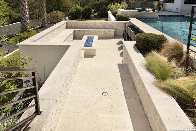 view of patio featuring a pool with hot tub