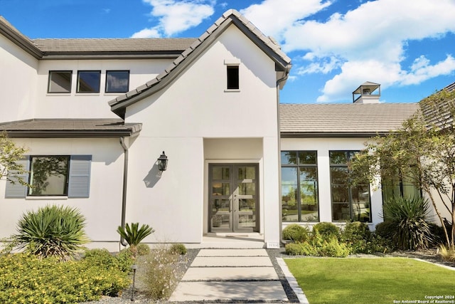 property entrance featuring a yard and french doors