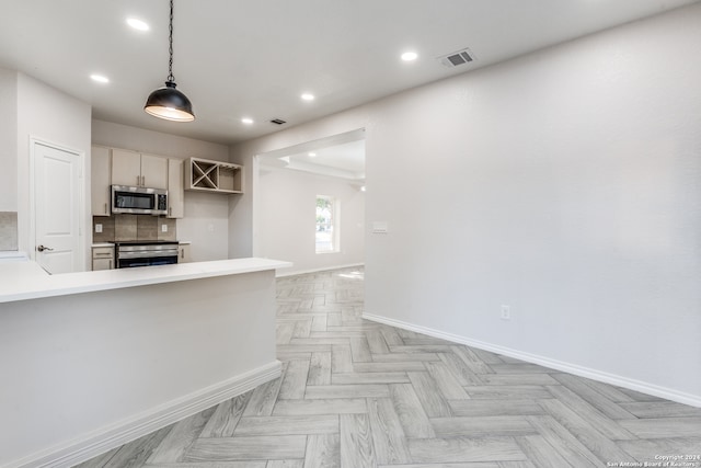 kitchen featuring stainless steel appliances, kitchen peninsula, tasteful backsplash, light parquet floors, and pendant lighting