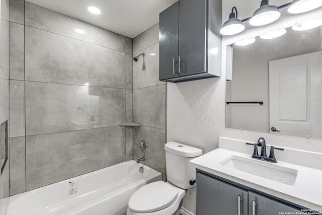 full bathroom with vanity, tiled shower / bath combo, and toilet