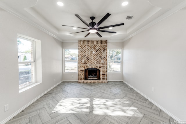 unfurnished living room featuring a raised ceiling, light parquet flooring, and ornamental molding