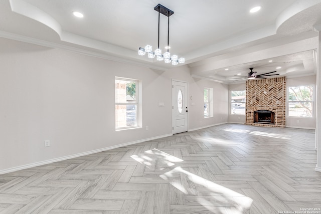 unfurnished living room with a wealth of natural light, crown molding, and a tray ceiling