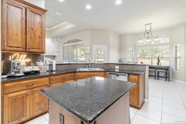 kitchen with a healthy amount of sunlight, a center island, and sink