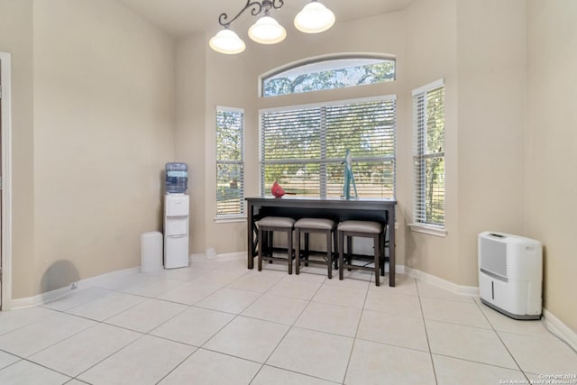 dining area with light tile patterned flooring and an inviting chandelier