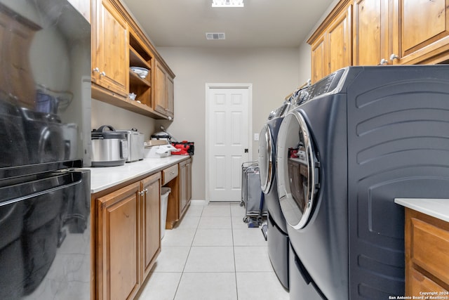 laundry area with cabinets, separate washer and dryer, and light tile patterned floors