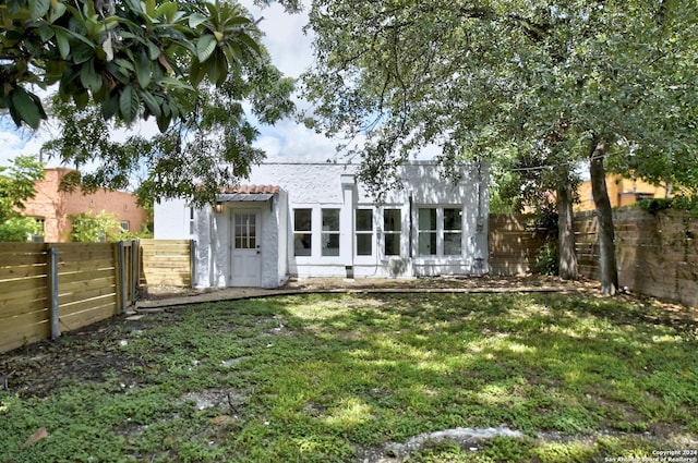 rear view of house featuring a yard