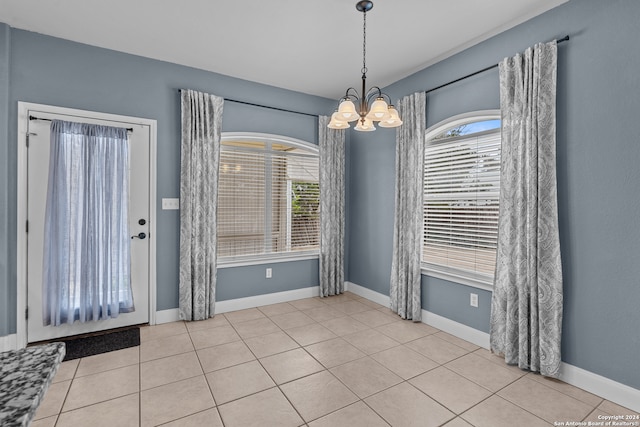 unfurnished dining area featuring a chandelier, light tile patterned floors, and plenty of natural light